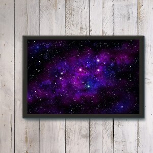 May include: A framed print of a dark purple and blue nebula with white stars. The nebula is a swirling cloud of gas and dust in space.