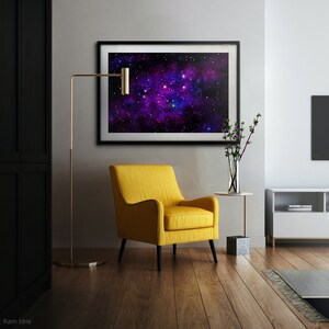 May include: A yellow armchair with a black metal frame sits in a living room with a black and white floor. A gold floor lamp stands next to the chair. A framed print of a galaxy with purple and blue hues hangs on the wall above a small side table.
