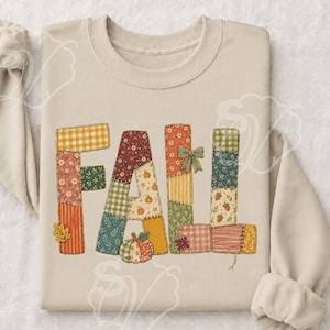 Könnte beinhalten: Ein beigefarbenes Sweatshirt mit Rundhalsausschnitt und dem Wort FALL in großen, blockartigen Buchstaben. Jeder Buchstabe ist mit einem Patchwork-Muster aus verschiedenen herbstlichen Stoffen in Orange, Grün, Gelb und Braun gefüllt, inklusive einer kleinen Kürbisgrafik.