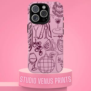 Könnte beinhalten: Eine rosa iPhone-Hülle mit einer schwarzen Umrissillustration von Speisen und Getränken, darunter ein Kuchen, Weingläser und Feigen. Die Hülle befindet sich auf einem rosa Sockel mit dem Text "STUDIO VENUS PRINTS".