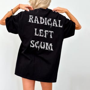 May include: Black t-shirt with the words "RADICAL LEFT SCUM" in a stylized, light gray font. The shirt is a basic crew neck style.