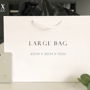 May include: White paper shopping bag with black text that reads "LUX HOMEWARE" and "LARGE BAG 40CM X 30CM X 13CM".