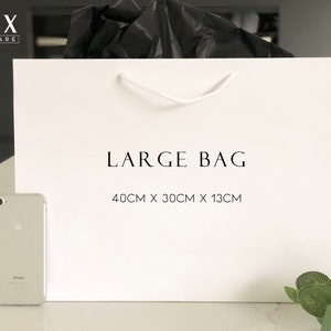 May include: White paper shopping bag with black text that reads "LUX HOMEWARE" and "LARGE BAG 40CM X 30CM X 13CM".
