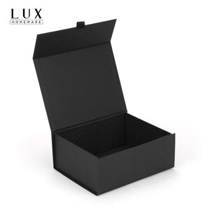 K&ouml;nnte beinhalten: Eine offene, schwarze Geschenkbox mit Magnetverschluss. Die Box ist rechteckig mit einem Klappdeckel und steht auf einer wei&szlig;en Oberfl&auml;che. In der oberen linken Ecke der Box steht der Text "LUX HOMEWARE".