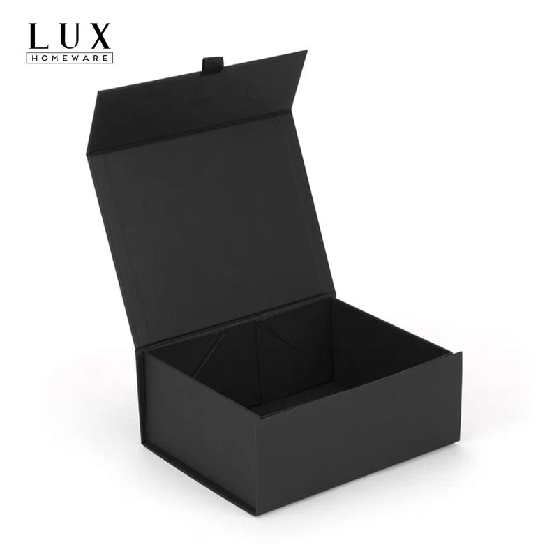 K&ouml;nnte beinhalten: Eine offene, schwarze Geschenkbox mit Magnetverschluss. Die Box ist rechteckig mit einem Klappdeckel und steht auf einer wei&szlig;en Oberfl&auml;che. In der oberen linken Ecke der Box steht der Text "LUX HOMEWARE".