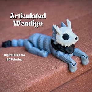 Puede incluir: Una figura articulada de Wendigo impresa en 3D, una criatura mítica con cuernos, una cabeza esquelética y una bufanda negra. La figura está en posición de tumbada con la cabeza girada hacia un lado. La figura está impresa en color azul claro.