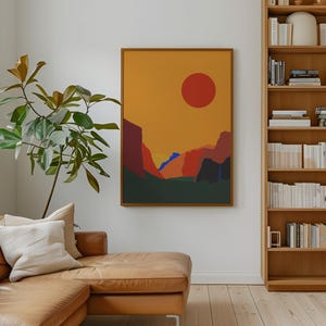 Puede incluir: Interior de salón con una pintura abstracta enmarcada que representa un sol rojo y montañas en tonos naranja, rojo y verde. Un sofá de cuero marrón, una estantería de madera llena de libros y una planta grande también están presentes.