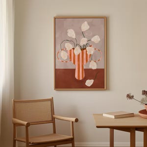 May include: Abstract art print featuring a vase with vertical orange stripes and white flowers. The vase is set against a muted background of brown and gray tones. The artwork is framed in a light wood frame.