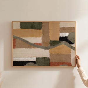 Peut inclure: Tableau abstrait encadré avec un motif patchwork aux tons neutres. L'œuvre d'art incorpore des formes rectangulaires et irrégulières dans des tons beige, marron, vert et noir, avec une fine ligne grise. Le cadre en bois ajoute une touche naturelle.