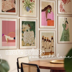 May include: A selection of framed art prints on a wall, showcasing diverse illustrations. The prints feature figures, floral arrangements, and abstract designs in a palette of pinks, greens, and neutral tones. The text "more prints you will love" is visible.