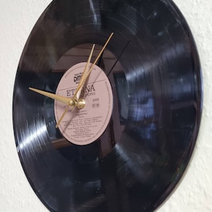 May include: A black vinyl record clock with gold hands. The record label is visible and reads "Eterna Recording AWA ST 33".
