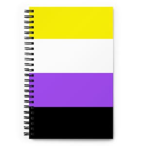 Puede incluir: Un cuaderno de espiral con una cubierta a rayas amarilla, blanca, morada y negra. Las rayas representan la bandera del orgullo no binario.