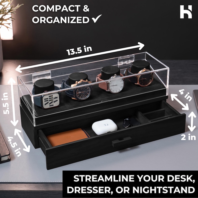 May include: A black watch organiser with a clear acrylic lid, measuring 34.3 cm wide, 14 cm high, and 10.2 cm deep. The organiser has a drawer that is 11.4 cm high and 5.1 cm deep. The text reads "COMPACT & ORGANIZED" and "STREAMLINE YOUR DESK, DRESSER, OR NIGHTSTAND."