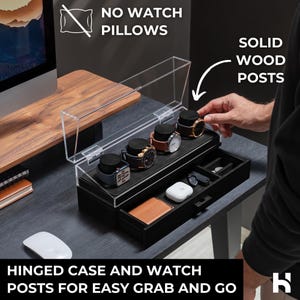 May include: A black watch display case with a clear hinged lid, featuring solid wood posts. The case holds several watches and has a drawer with small compartments. Text on the image reads "NO WATCH PILLOWS" and "HINGED CASE AND WATCH POSTS FOR EASY GRAB AND GO."