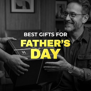 May include: A black gift box with a silver ribbon is being handed to a smiling man. The text "BEST GIFTS FOR FATHER'S DAY" is in yellow and white.