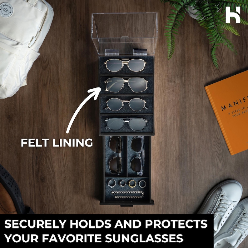 May include: A vertical black storage organizer with a clear hinged lid and a pull-out drawer. The interior features grey felt lining, four upper slots for sunglasses, and lower compartments for additional eyewear and small jewelry items.