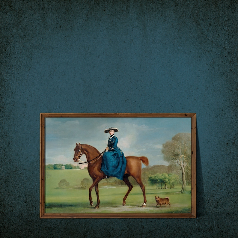 May include: A framed oil painting depicting a woman in a blue dress riding a brown horse. The woman is wearing a wide-brimmed hat and holding the reins. The horse is walking through a grassy field with a small dog running behind it.