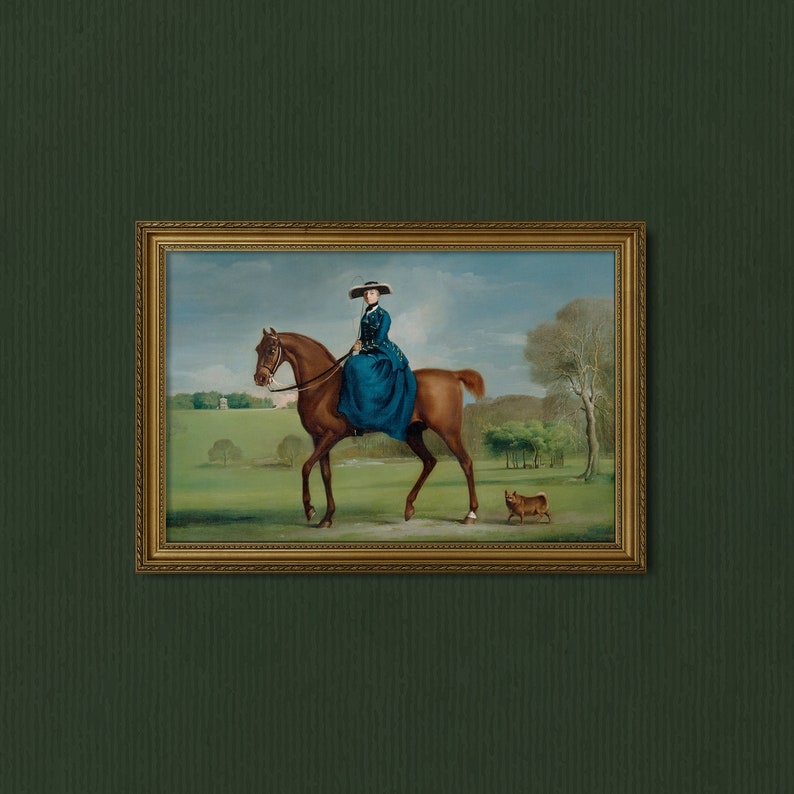 May include: A framed oil painting depicting a woman in a blue dress riding a brown horse through a green field. A small brown dog is walking behind the horse.