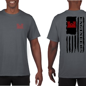 May include: A charcoal grey t-shirt with a red US Army Engineer Corps insignia on the left chest and a black and white distressed American flag with the text "ENGINEERS" on the back.