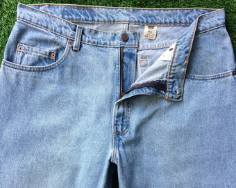 Puede incluir: Vaqueros de mezclilla azul claro con cierre de cremallera y una etiqueta Levi's 540. Los vaqueros están desabrochados y la cremallera está parcialmente abierta.