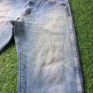 May include: A pair of light blue denim jeans with a straight leg fit. The jeans have a button fly and belt loops.