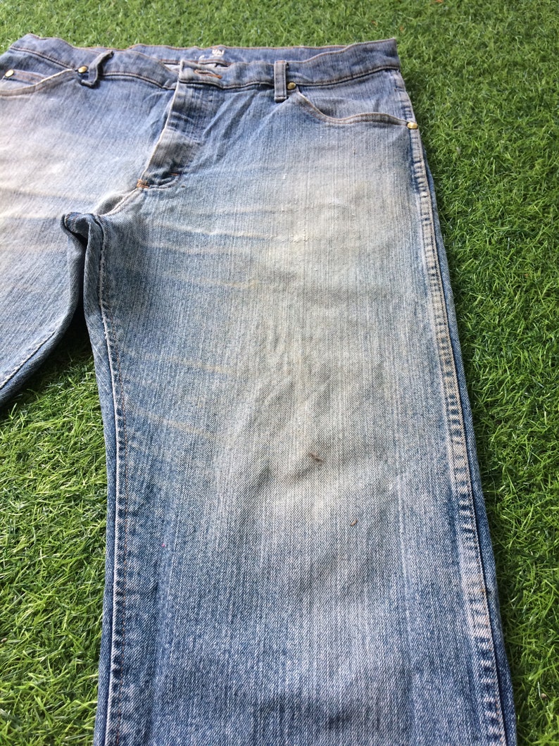 May include: A pair of light blue denim jeans with a straight leg fit. The jeans have a button fly and belt loops.