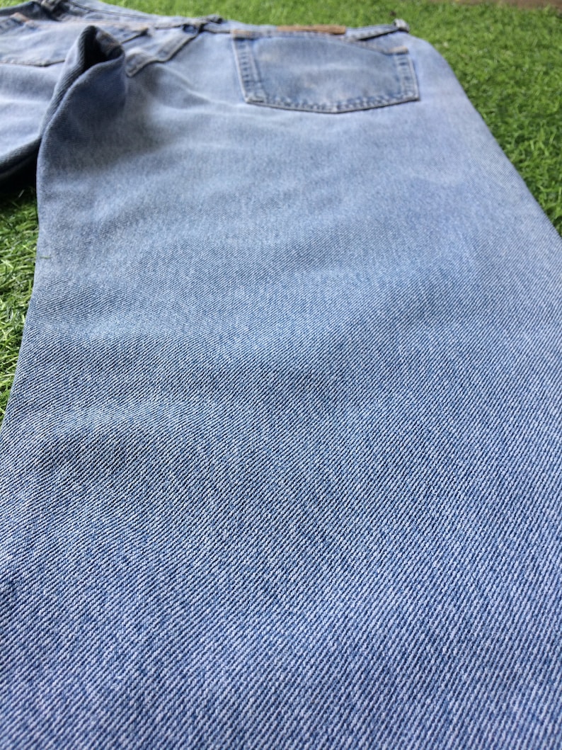 Pode incluir: Um par de cal&ccedil;as de ganga azul claro com um bolso traseiro. As cal&ccedil;as de ganga s&atilde;o feitas de um material macio e confort&aacute;vel e t&ecirc;m um corte cl&aacute;ssico.