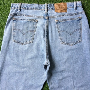 May include: Light blue denim jeans with a brown leather patch on the back pocket that says "Levi Strauss & Co.".