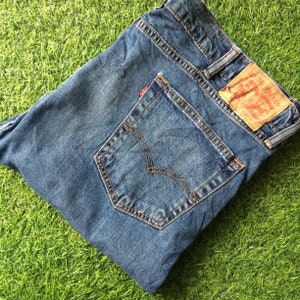 May include: A pair of blue denim jeans with a back pocket and a Levi's label. The label says "Levi's" and "San Francisco, Ca."