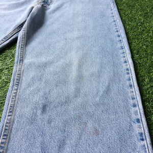 May include: Light blue denim jeans with a faded wash and a straight leg fit.