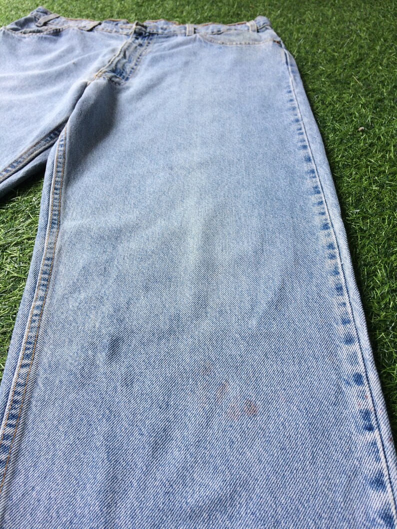 May include: Light blue denim jeans with a faded wash and a straight leg fit.