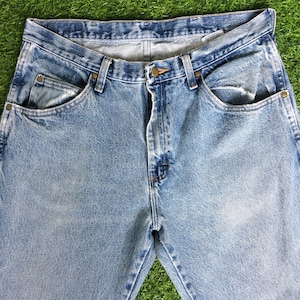May include: A pair of light blue denim jeans with a classic five-pocket style. The jeans have a faded look and are made of a soft, comfortable cotton blend.