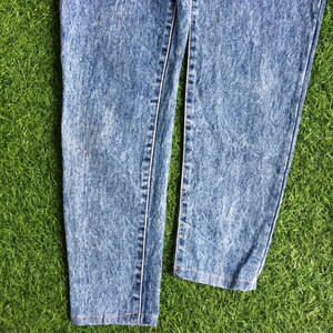 May include: A pair of light blue acid wash denim jeans with a straight leg fit. The jeans have a faded look and are made of a soft, comfortable material.