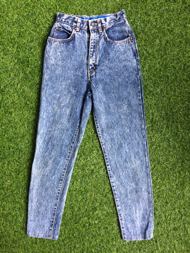 May include: Light blue acid wash denim jeans with a high waist and a straight leg.