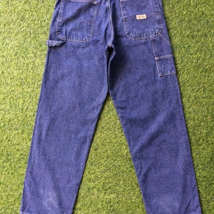May include: A pair of blue denim carpenter jeans with a brand label on the back right pocket.