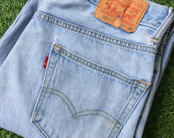 May include: Light blue denim jeans with a back pocket and a Levi Strauss & Co. patch with the text "550" and "34 30".