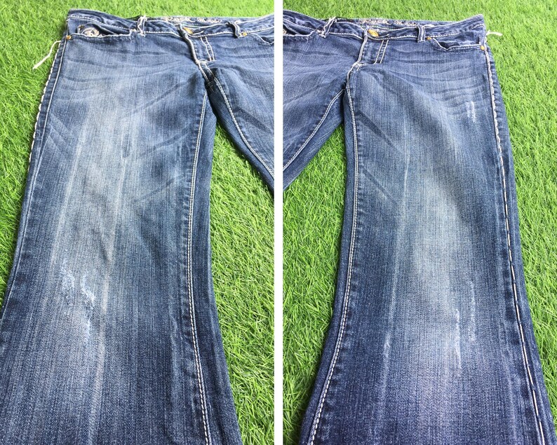Op de afbeelding: Een paar blauwe denim jeans met een vervaagde look en stiksels. De jeans heeft een rechte pijp en een klassiek ontwerp met vijf zakken.
