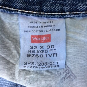 May include: A white tag with black text and a red Wrangler logo. The tag says "Made in Mexico, Hecho en Mexico, 100% Cotton/Algodon". Below the logo, the tag says "32 X 30 Relaxed Fit 97601VR SPS-1286-001 6727879037153".