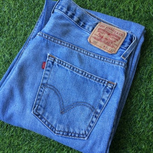 W33 L30 Vintage Distressed Levis 550 Jeans Light Wash Rigid Denim Classic Relaxed Fit Tapered Leg Jeans. 33 x 30