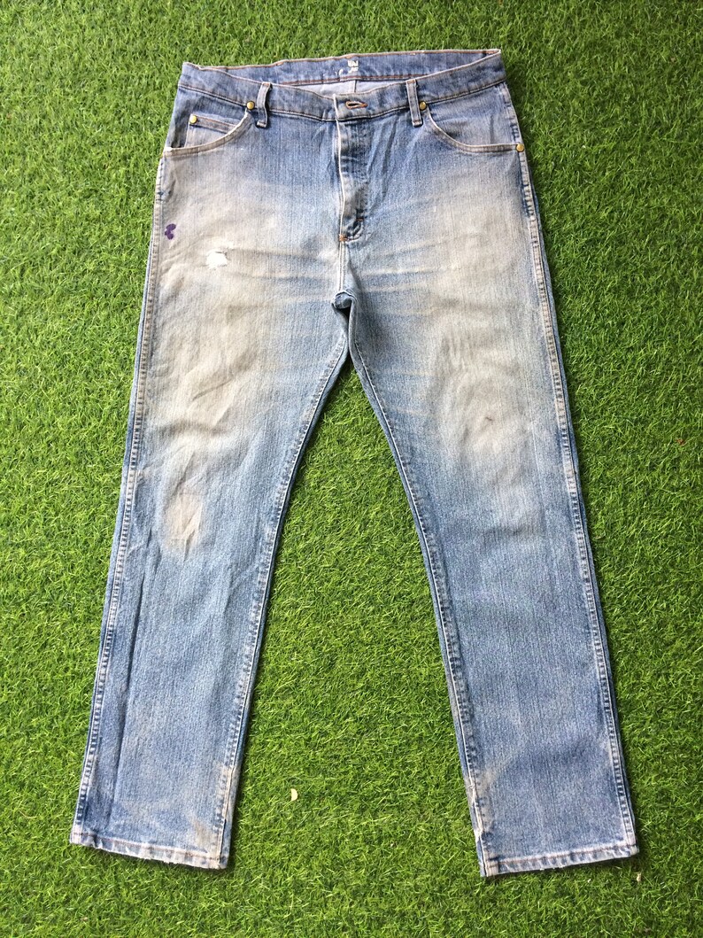 May include: A pair of light blue denim jeans with a faded look. The jeans have a straight leg and a classic five-pocket design.