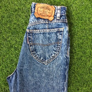 May include: Light blue denim jeans with a brown leather patch that says "Something The Only Classic Edwin".