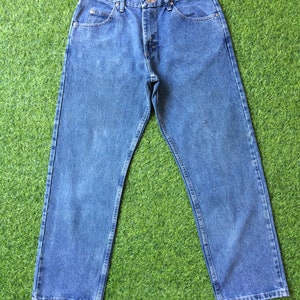 May include: A pair of blue denim jeans with a classic straight leg fit. The jeans have a button fly and five pockets.