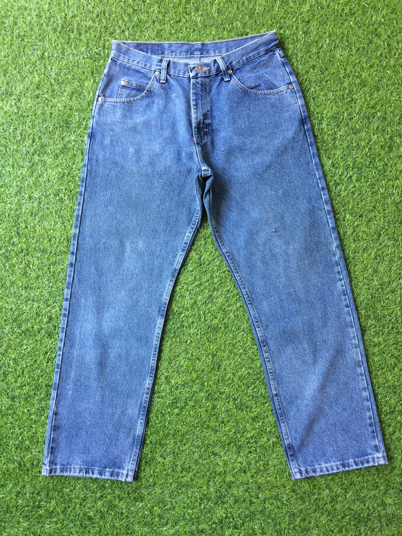 May include: A pair of blue denim jeans with a classic straight leg fit. The jeans have a button fly and five pockets.