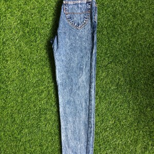 May include: Light blue acid wash denim jeans with a brown leather patch that says "Something Special" on the back.