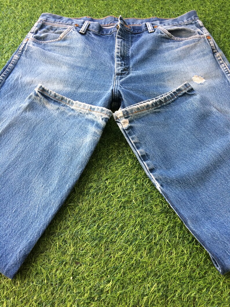 May include: A pair of light blue denim jeans with a faded look. The jeans have a straight leg and a classic five-pocket design.