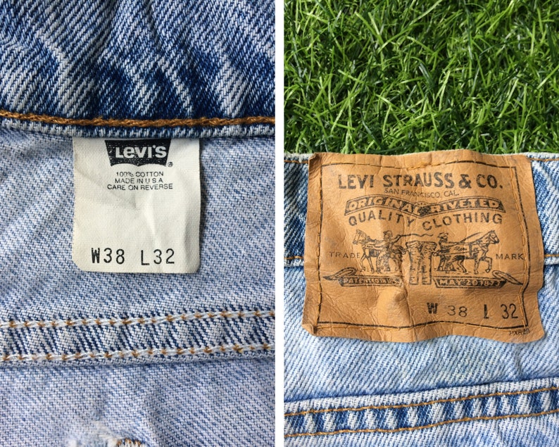 May include: A pair of blue denim jeans with a brown leather Levi's label. The label says "Levi Strauss & Co. San Francisco Cal. Original Rivited Quality Clothing" and has the size "W 38 L 32".