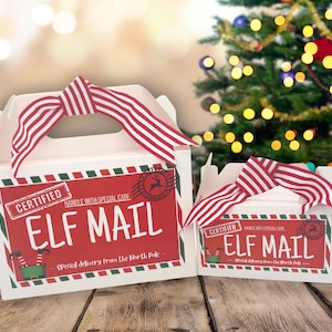 Peut inclure: Deux boîtes blanches avec des rubans à rayures rouges et blanches, étiquetées "ELF MAIL" en rouge et vert. Les boîtes ont un design festif avec le texte "Special delivery from the North Pole."
