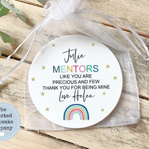 May include: A white ceramic plate with a rainbow design and the text "Julie MENTORS LIKE YOU ARE PRECIOUS AND FEW THANK YOU FOR BEING MINE Love Helen" in colourful letters. The plate is in a white organza bag.