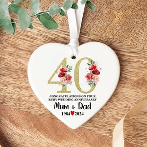 May include: White ceramic heart-shaped ornament with gold glitter 40 and red and pink floral design. The text reads "Congratulations on your Ruby Wedding Anniversary Mum & Dad 1984 ♥ 2024".