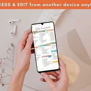 Puede incluir: Un tel&eacute;fono inteligente muestra una lista de verificaci&oacute;n de "Baby Essentials", sostenido por una persona. La pantalla presenta categor&iacute;as como ropa, equipo y actividades, con ilustraciones. El texto en la parte superior dice "ACCESS & EDIT from another device anytime."